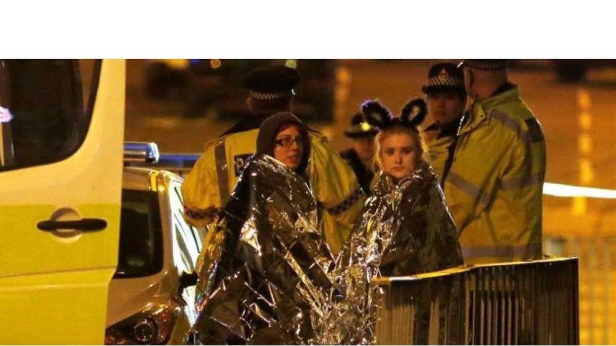 Dos chicas son atendidas por los servicios de emergencia a las afueras del Manchester Arena.-REUTERS