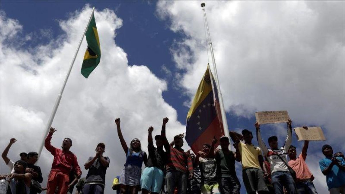 Un grupo de gente protesta en la frontera entre Brasil y Venezuela.-REUTERS / RICARDO MORAES