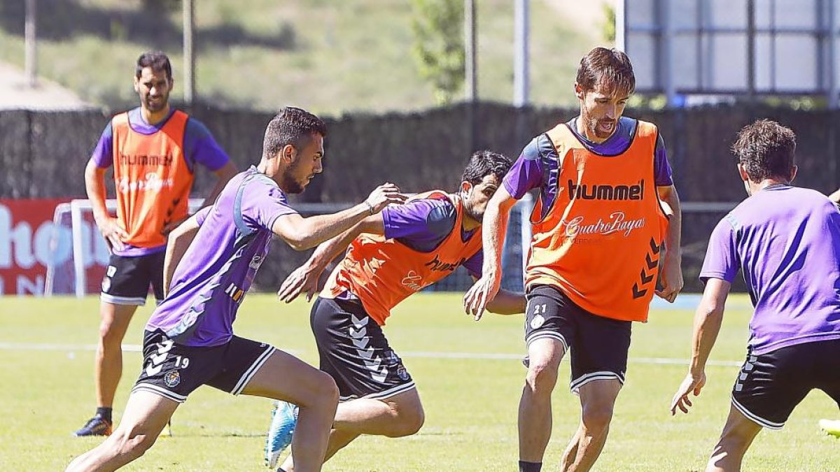Míchel conduce el balón durante un entrenamiento y Jordán, de perfil, corre para arrebatárselo-J.M. Lostau