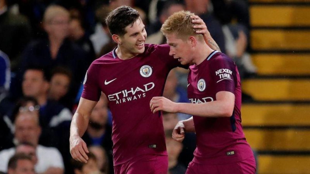 De Bruyne celebra con Stones su gol ante el Chelsea.-AFP / EDDIE KEOGH