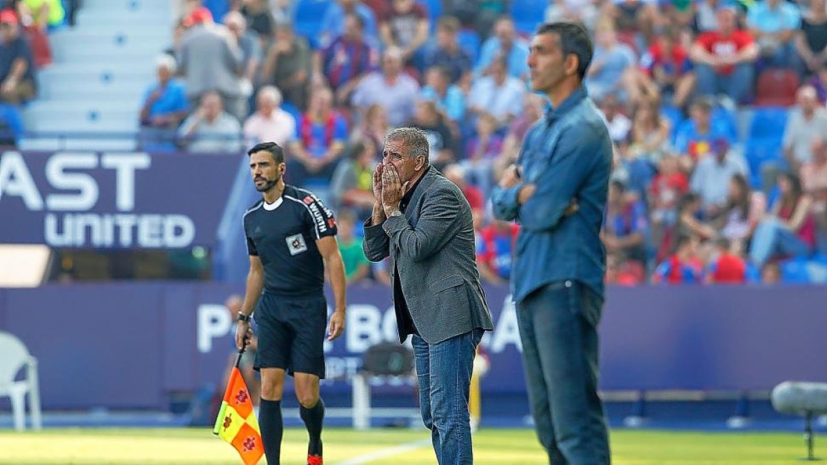 Paco Herrera vocea una orden ante un relajado Muñiz y el árbitro auxiliar.-ARABA PRESS