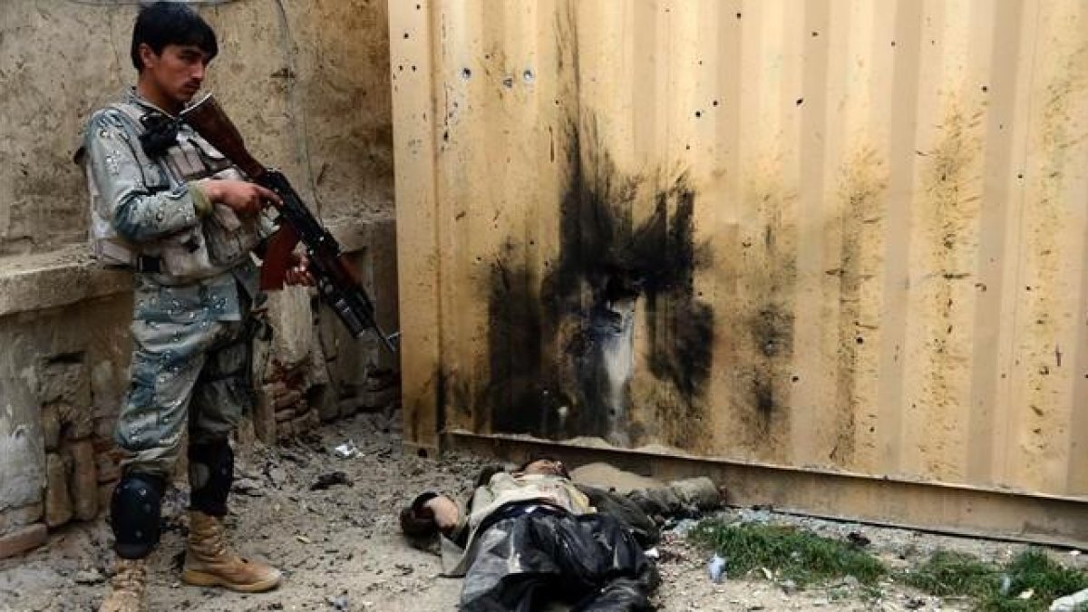 Un soldado afgano junto al cuerpo de un talibán muerto en un ataque en las cercanías de Kandahar.-AFP