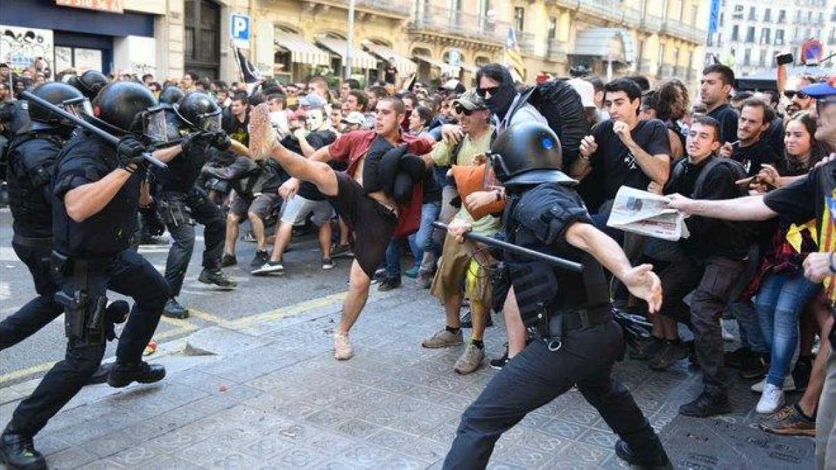 Policías tratando de contener a grupos soberanistas.-