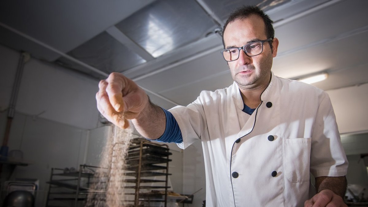 José Ángel Carnicero remata unas torrijas en su obrador con azúcar y canela. / GONZALO MONTESEGURO