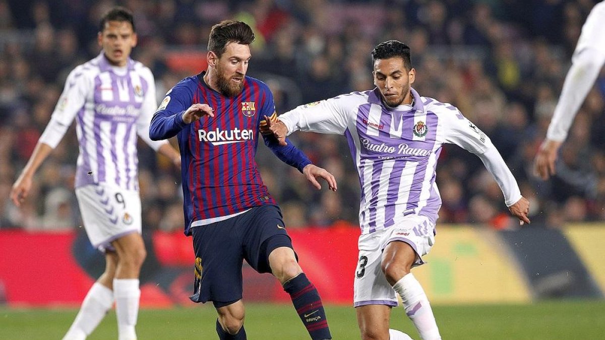 El blanquivioleta Anuar impide el control de balón del azulgrana Messi, ante la mirada de Ünal.-ALBERT GEA / REUTERS