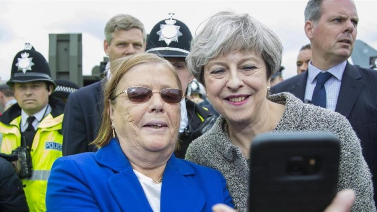 May (derecha) posa para un selfi con una asistente a una exhibición militar en Liverpool, el 24 de junio.-OWEN COOBAN