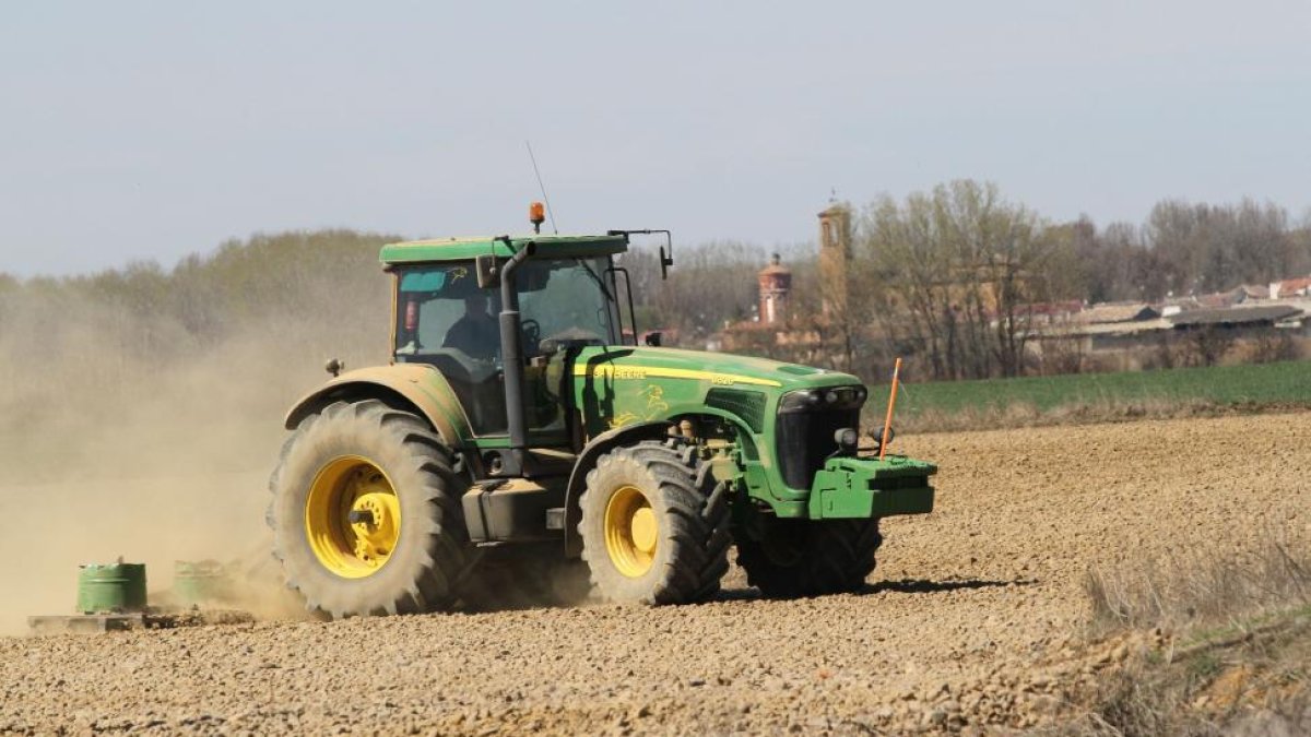 Un agricultor en su tractor realiza distintas labores agrícolas en su parcela.-BRÁGIMO