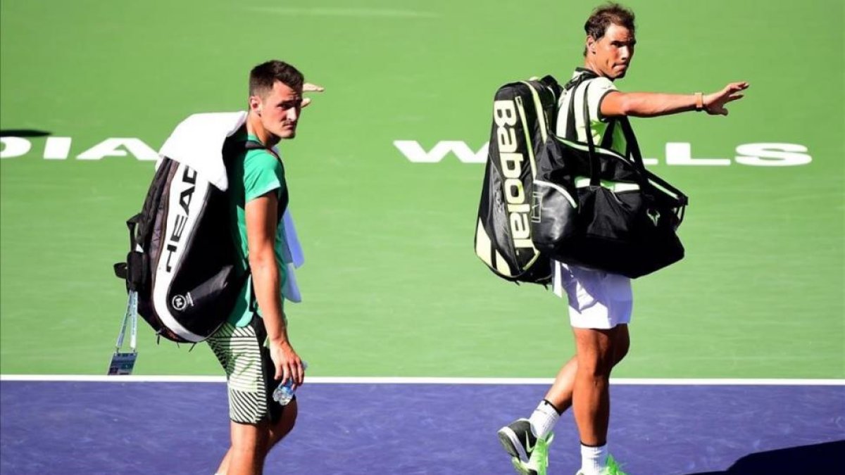 Nadal y Tomic se despiden de la afición tras perder el partido de dobles.-AFP / HARRY HOW
