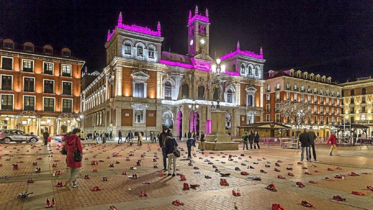 Edificio consistorial iluminado de morado y los zapatos rojos de recuerdo a las víctimas.-Pablo Requejo