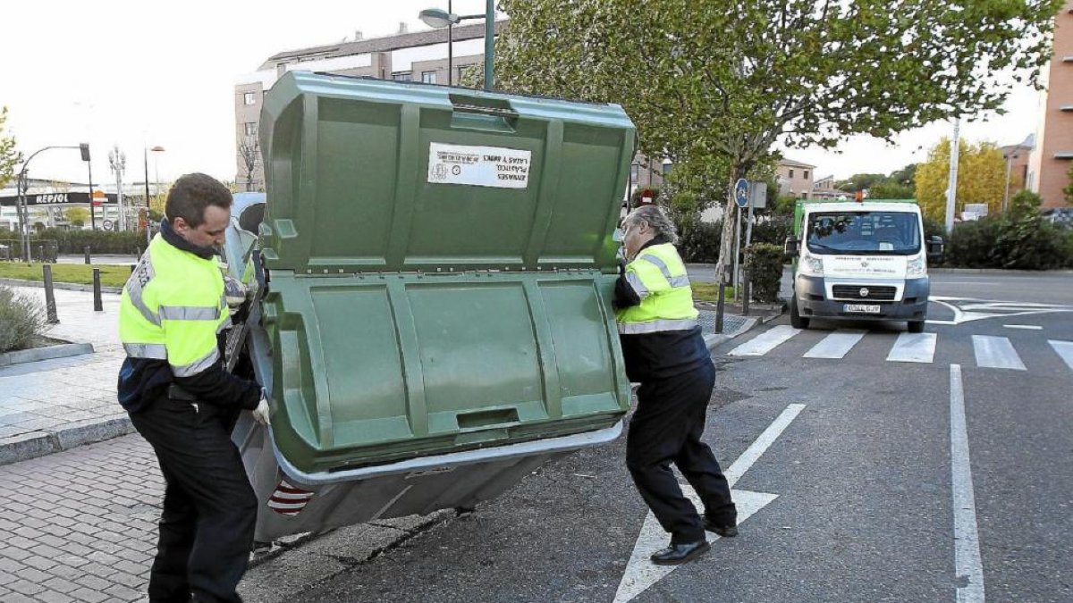 Operarios del Servicio de Limpieza retiran un contenedor volcado en la calzada-J. M. LOSTAU