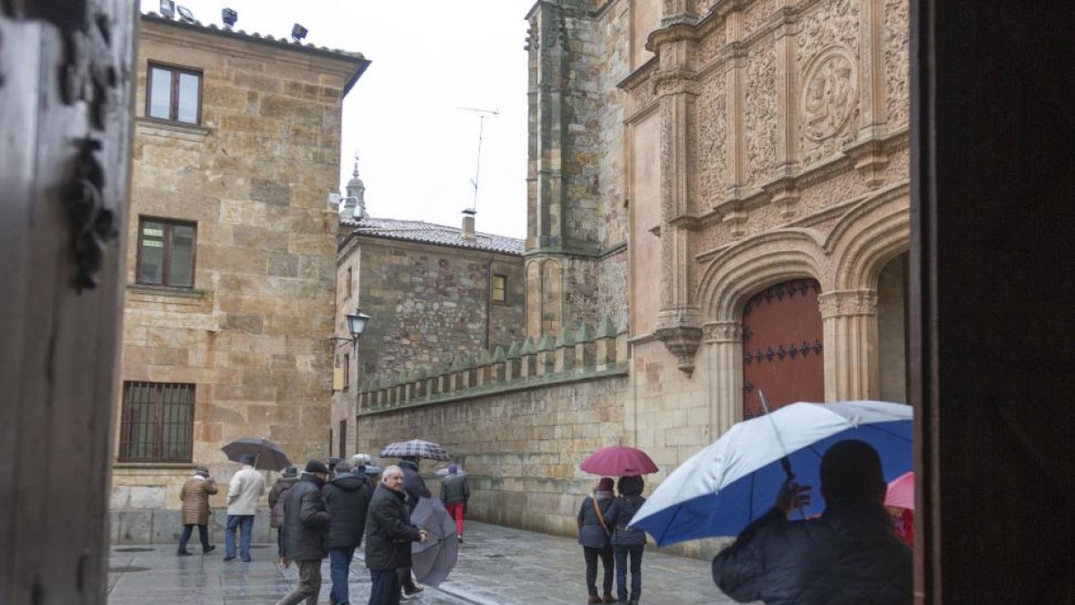 Varios ciudadanos salmantinos se protegen de la lluvia.-ICAL