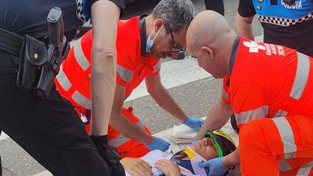 El joven ciclista es inmovilizado tras el atropello por dos enfermeros. / EM