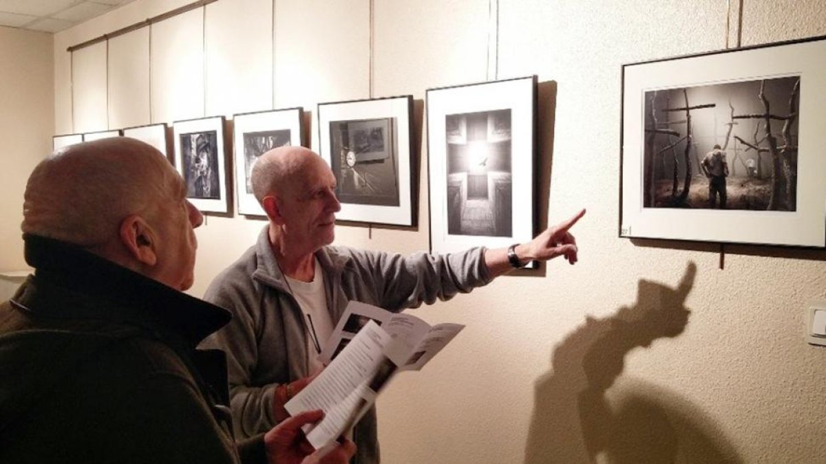 Dos hombres observan la foto ganadora en la exposición del XII Salón de Fotografía.-AFV