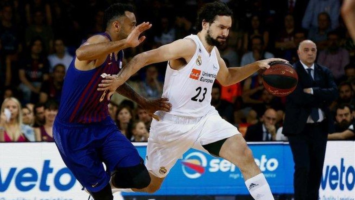 El madridista Llull empuja con la mano a Hanga, intentando evitar su defensa / ENRIC FONTCUBERTA (EFE)-EFE / ENRIC FONTCUBERTA (EFE)