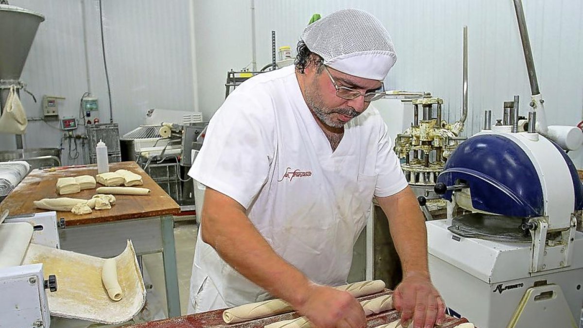 Bizien Serrano da forma a las barras fabiola en el obrador de la panadería San Francisco de Palencia.-BRÁGIMO
