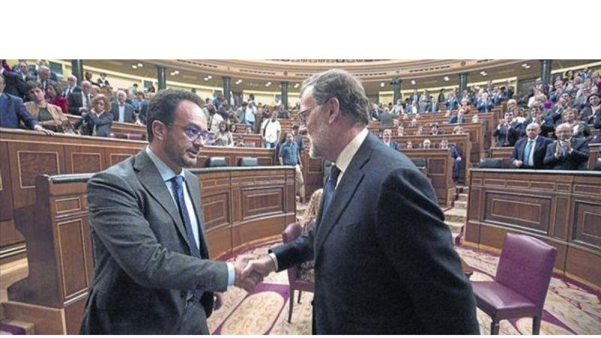 Mariano Rajoy y el socialista Antonio Hernando se dan la mano tras la segunda votación del pleno de investidura.-POOL