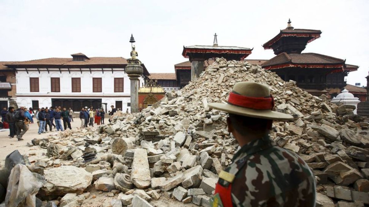 Un grupo de personas observa un templo nepalí destruido tras el terremoto-El Mundo