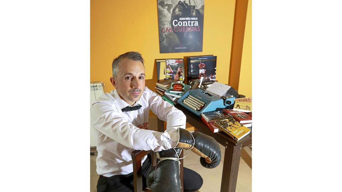 Sergio Núñez Vadillo posa junto a su máquina de escribir rodeado de su colección de libros.-J.M.LOSTAU
