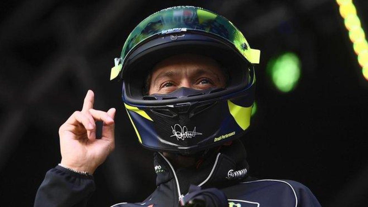 Valentino Rossi se pone su casco antes de subastarlo, en Silverstone, para que todo el mundo vea que es el suyo.-MILAGRO / TINO MARTINO