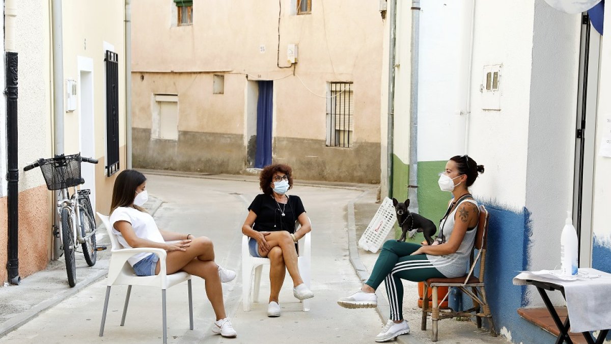 Vecinas de Pesquera de Duero dialogan con sus mascarillas en una de las calles de la localidad. J.M. LOSTAU