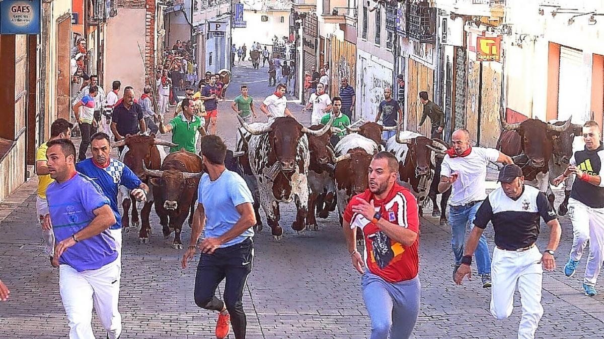Los corredores aceleran sus pasos ante el último encierro de las fiestas de la localidad segoviana de Cuéllar.-ICAL