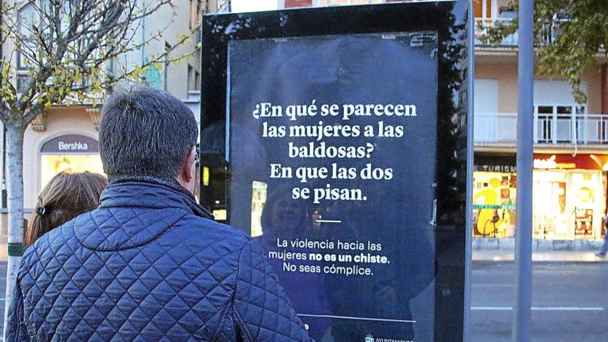 Un vecino contempla uno de los chistes de la campaña.-E. M.