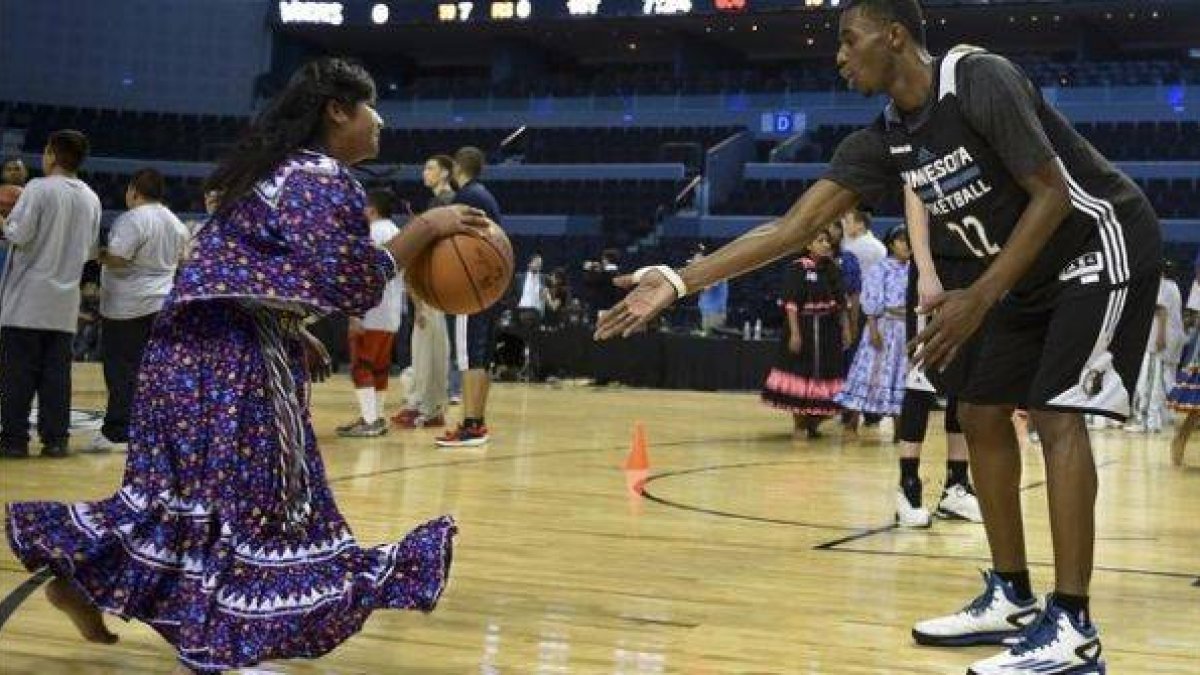 Una jugadora mexicana ataviada con un traje típico, con un jugador del Minnesota.-Foto: AFP / YURI CORTEZ