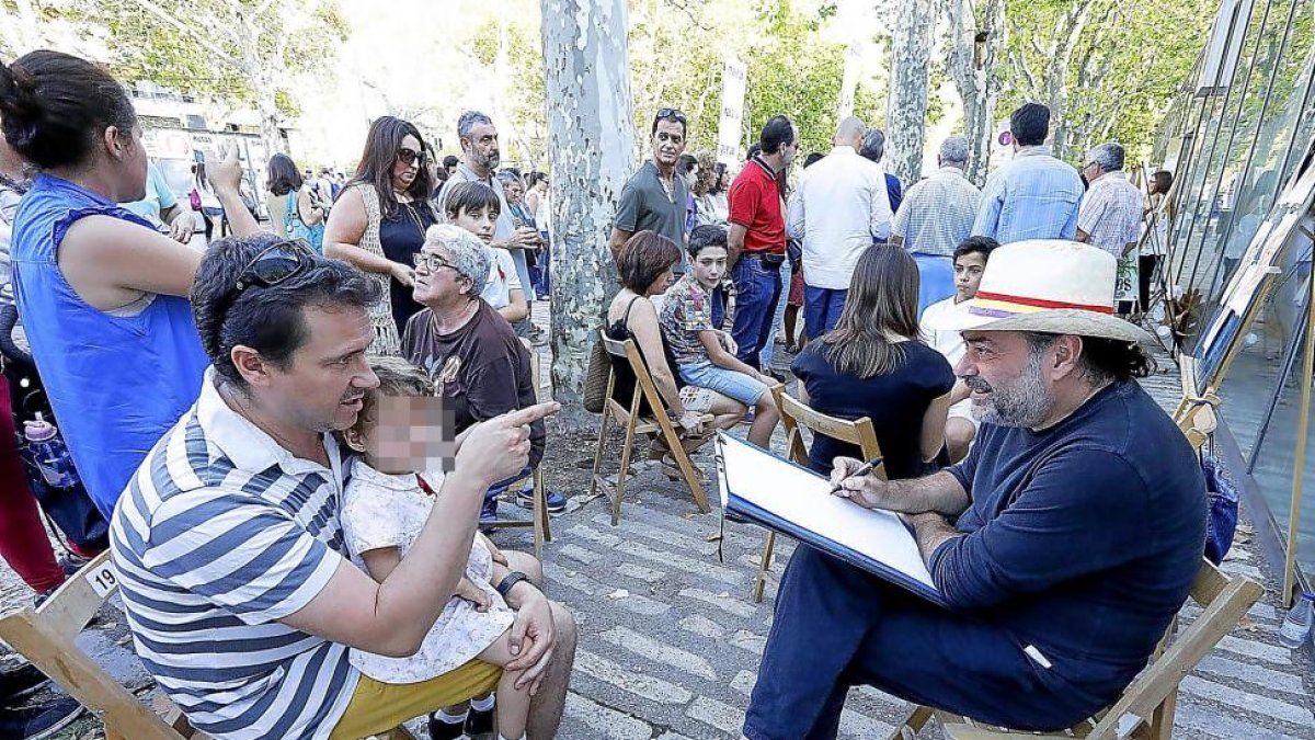 Un padre sostiene a su pequeña en brazos para que sea retratada.-PABLO REQUEJO / PHOTOGENIC