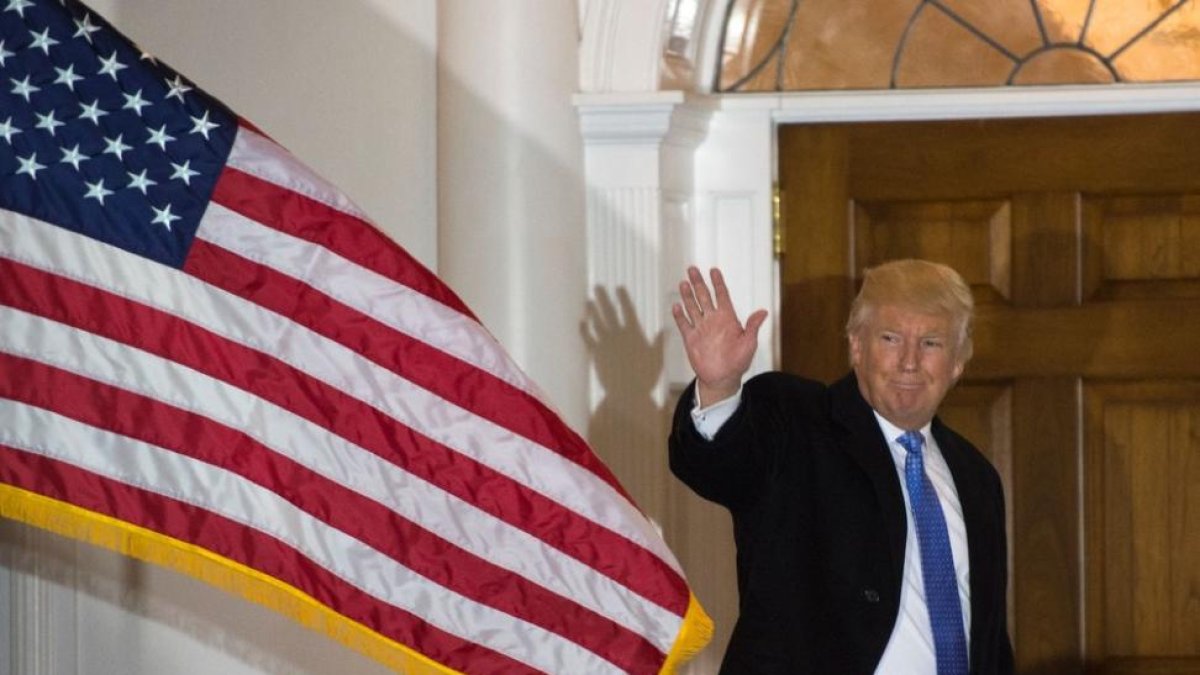 Trump saluda a los medios, en la entrada del club de golf que lleva su nombre, en Bedminster.-AFP / DON EMMERT