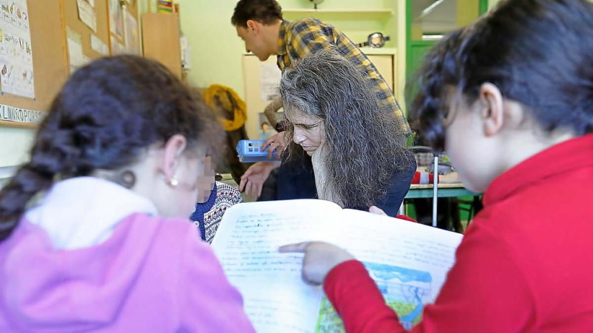 Isabel y Rodrigo, de Azacán, ayudan a varios alumnos de Primaria en una clase de apoyo extraescolar para niños inmigrantes en el Pablo Picasso.-J.M.LOSTAU