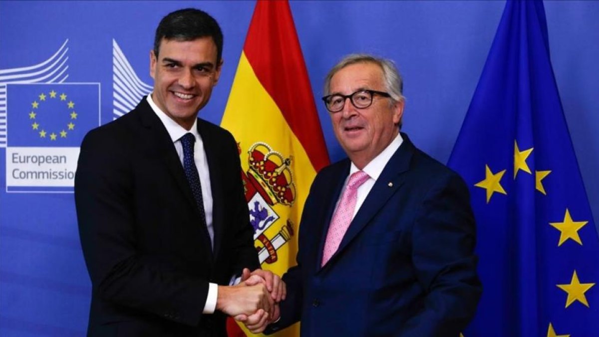 Sánchez y Juncker se saliudan antes de la reunión que han mantenido previa a la cumbre de la UE.-AFP