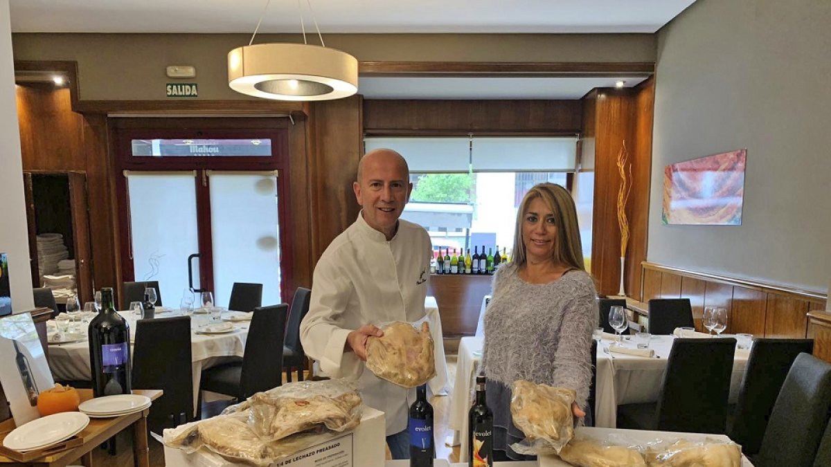 Óscar y Jessica con parros y cuartos de lechazo envasados al vacío en el comedor del Maracaibo