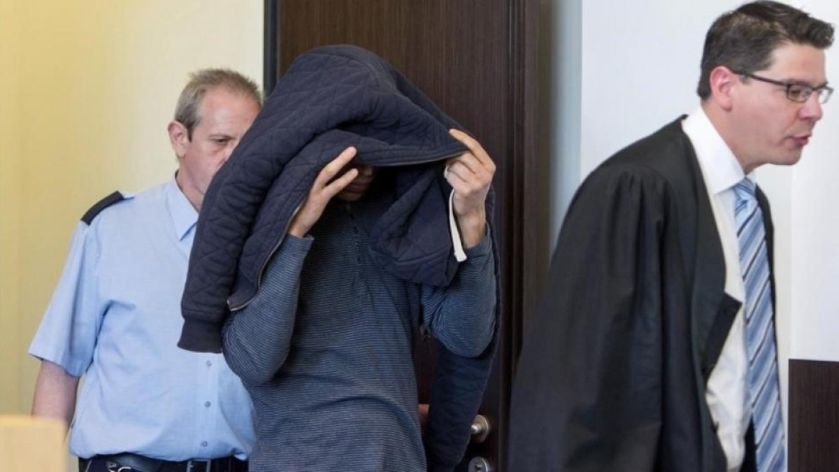 El acusado Toufik M. (centro) entra en la sala del tribunal lunto a su abogado, antes de iniciarse el juicio, en Düsseldorf, este lunes.-EFE / MONIKA SKOLIMOWSKA