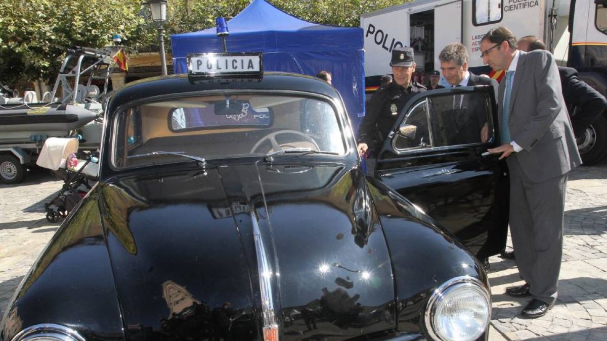 El director general de la Policía, Ignacio Cosidó (C) observa un antiguo coche de la policía, junto al alcalde, Alfonso Polanco; en su visita a una muestra sobre vehículos y material utilizados por la Policía-Ical