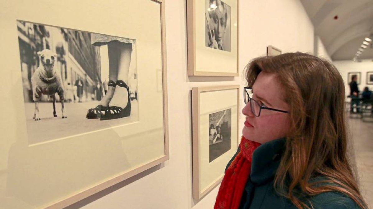 Una mujer observa las imágenes de la exposición de fotografías de Lola Garrido-J.M.Lostau