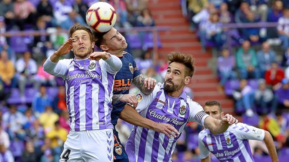 Keko y Borja saltan por un balón con Santi Mina durante el polémico Valladolid-Valencia.-J.M.LOSTAU