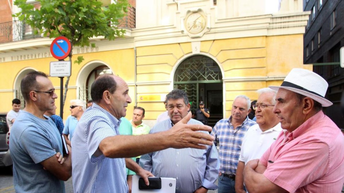 Miguel Ángel Peláez (2I), conversa con algunos agricultores tras mantener una reunión con la CHD para la demanda de agua.-ICAL