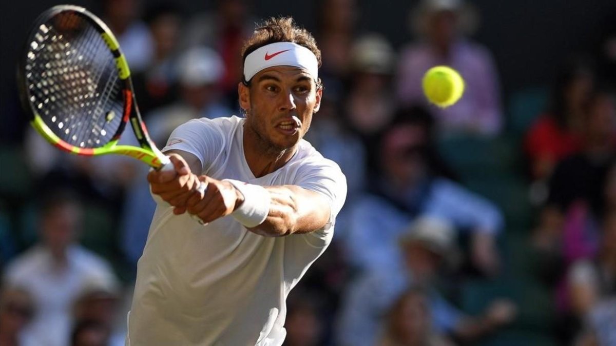 Nadal golpea un revés ante Del Potro en Wimbledon.-AFP / GLYN KIRK