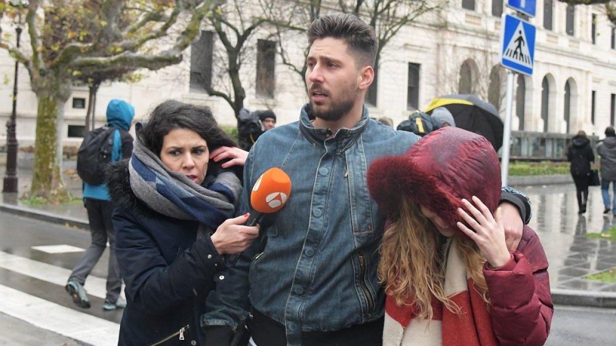Víctor Rodríguez se aleja del Palacio de Justicia de Burgos junto a su novia perseguido por una redactora de televisión.-ICAL