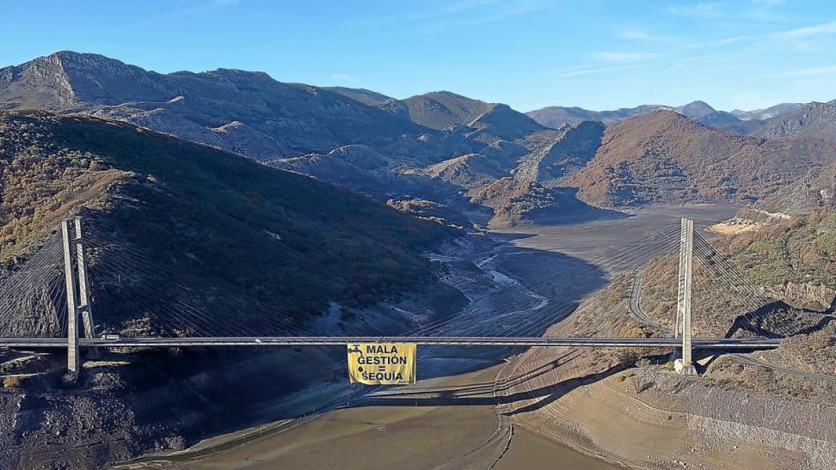 Viaducto del pantano de Barrios de Luna con la pancarta colocada ayer por Greenpeace para denunciar la mala gestión del agua.-E.M.