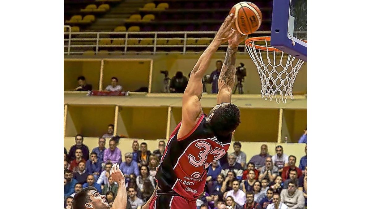 Jito Kok intenta, sin suerte, un alley-hoop de espaldas ante Figueras y Kurucs.-M.A. SANTOS