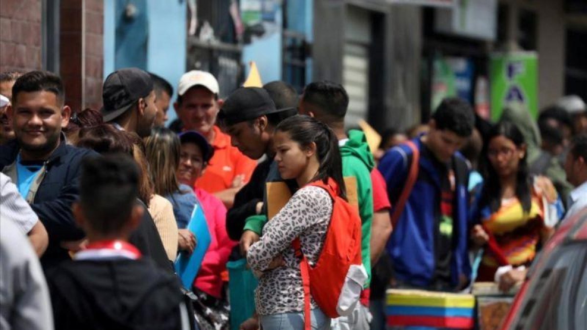 Refugiados venezolanos esperan en lla cola de la oficina de inmigración en Lima.-MARIANA BAZO (REUTERS)