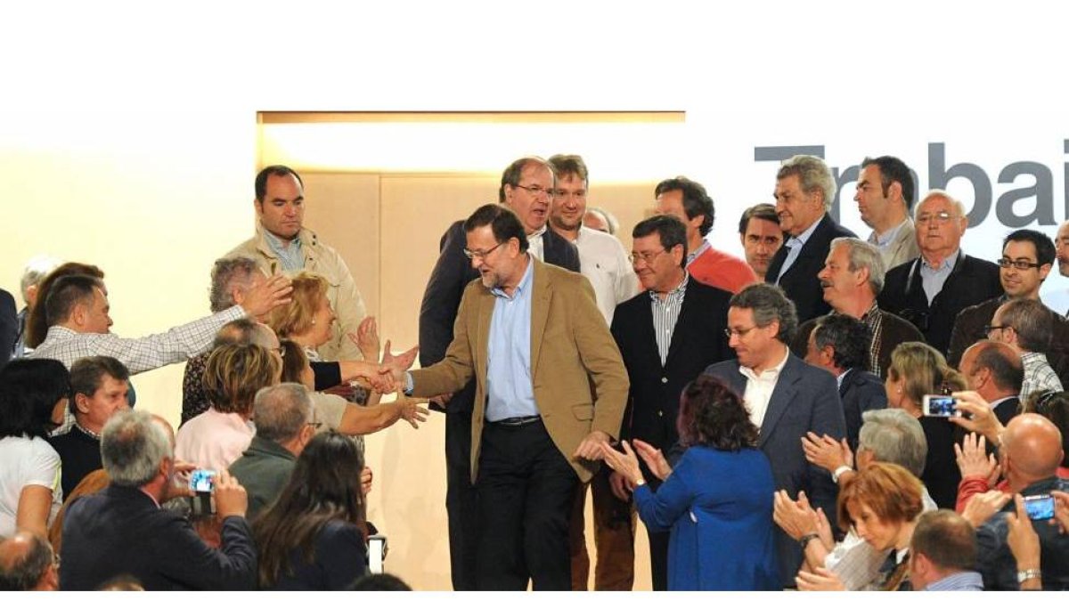 El presidente del Gobierno saluda a los simpatizantes del PP mientras baja las escaleras en el Fórum Evolución. A la derecha, Rico. Tras él, Herrera, Lacalle, Floriano y Posada.-Israel L. Murillo