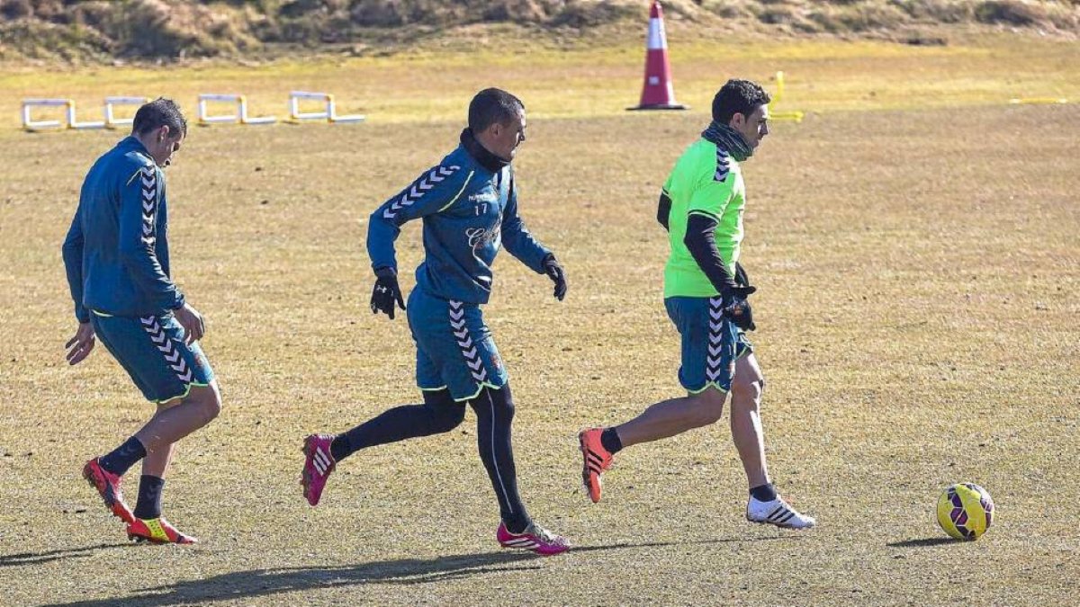 Óscar corre con el balón perseguido por su compañero Peña, durante el entrenamiento del lunes-Pablo Requejo