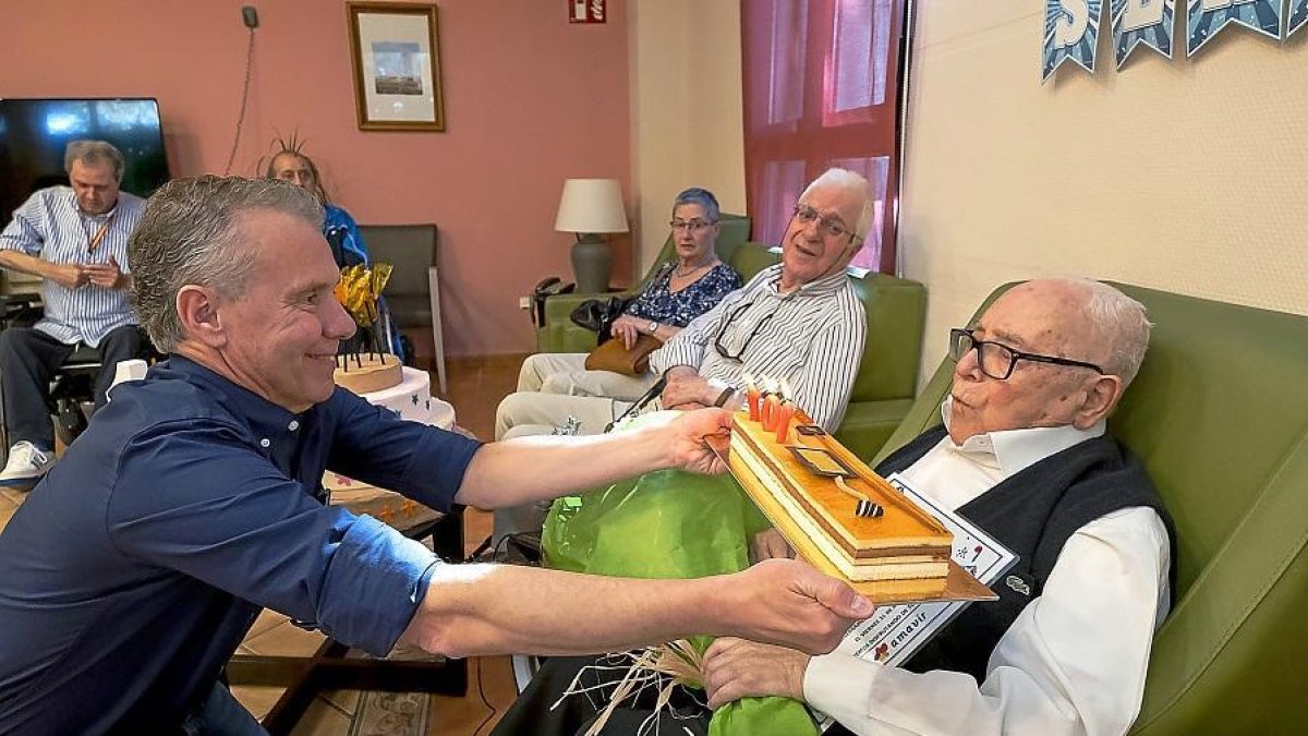 Sergio Palacios sopla la tarta con la vela de los 107 años ante la presencia de su sobrino Julio.-PABLO REQUEJO