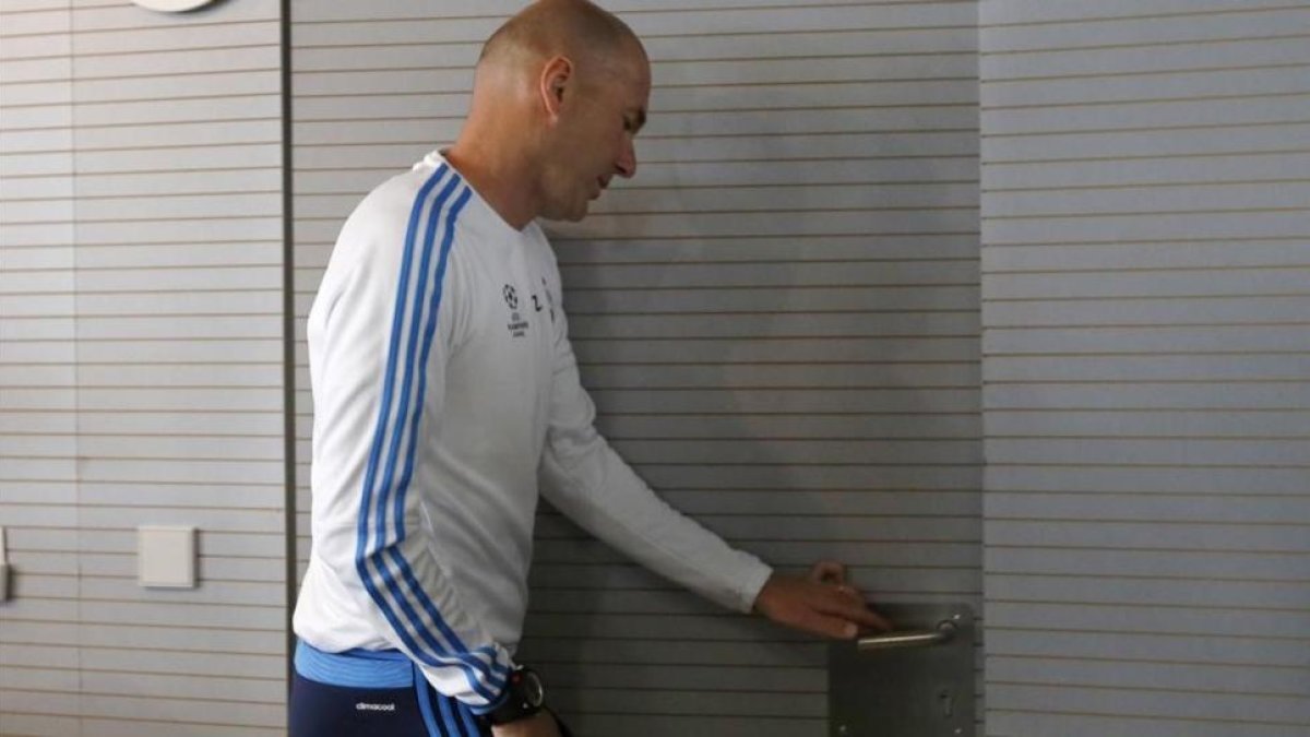 Zinedine Zidane abandona la sala de prensa de Valdebebas tras su comparecencia ante los periodistas.-JUAN MANUEL PRATS