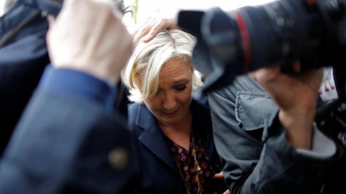 Marine Le Pen, protegida por sus guardaespaldas del lanzamiento de huevos.-STEPHANE MAHE