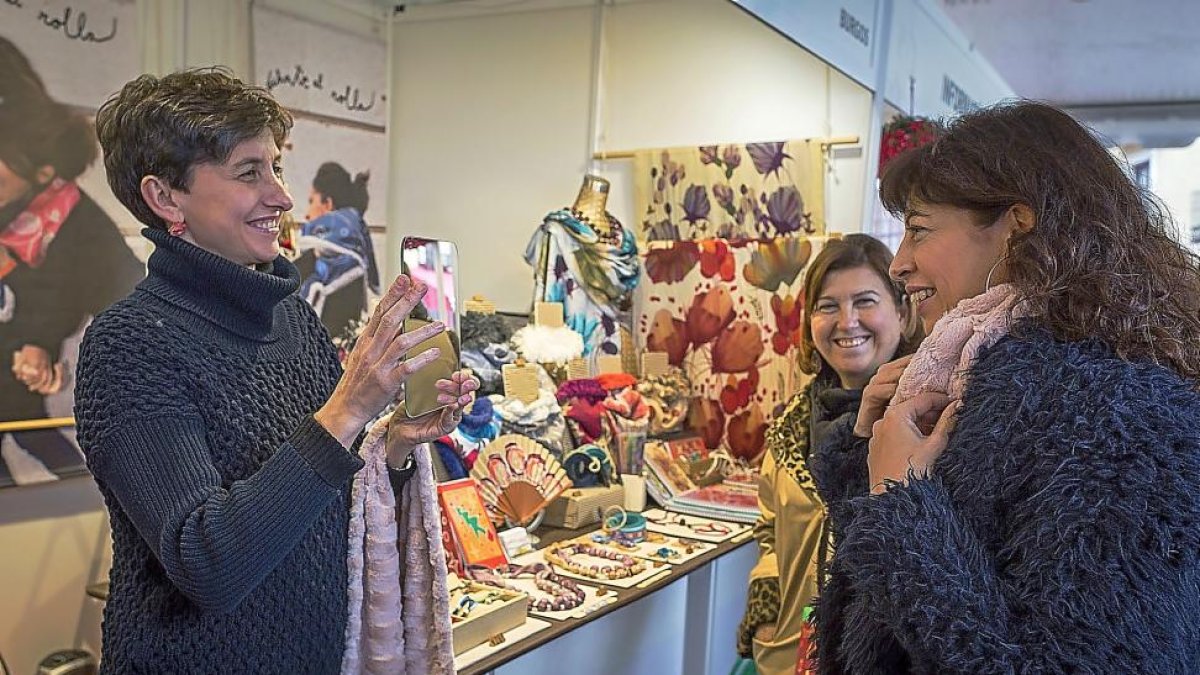 Ana Redondo conversa con la dueña del stand  ‘Échate el rollo’ de la Feria de Artesanía de Navidad.-MIGUEL ÁNGEL SANTOS
