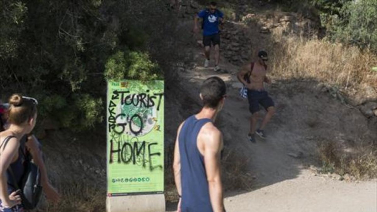 Turismofobia 8 Pintada contra el turismo en un cartel, en uno de los accesos al Parc Güell.-JORDI COTRINA