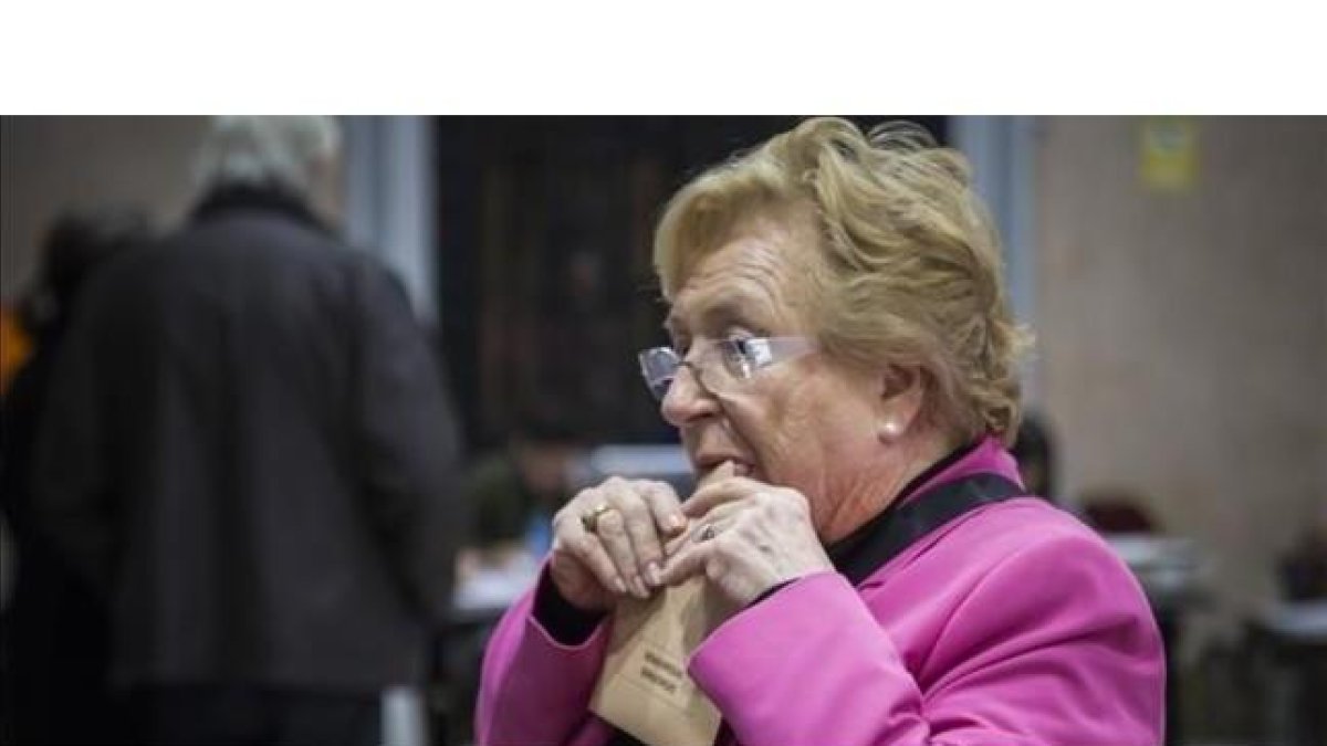 Una mujer cierra el sobre antes de votar en un colegio electoral de Valencia.-MIGUEL LORENZO